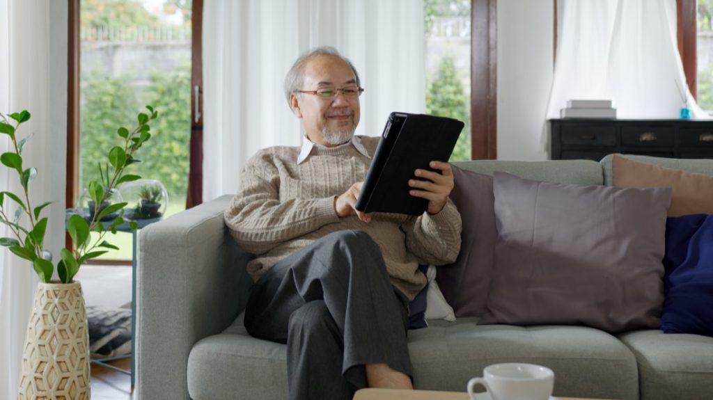 A member relaxing at home while reading on a tablet